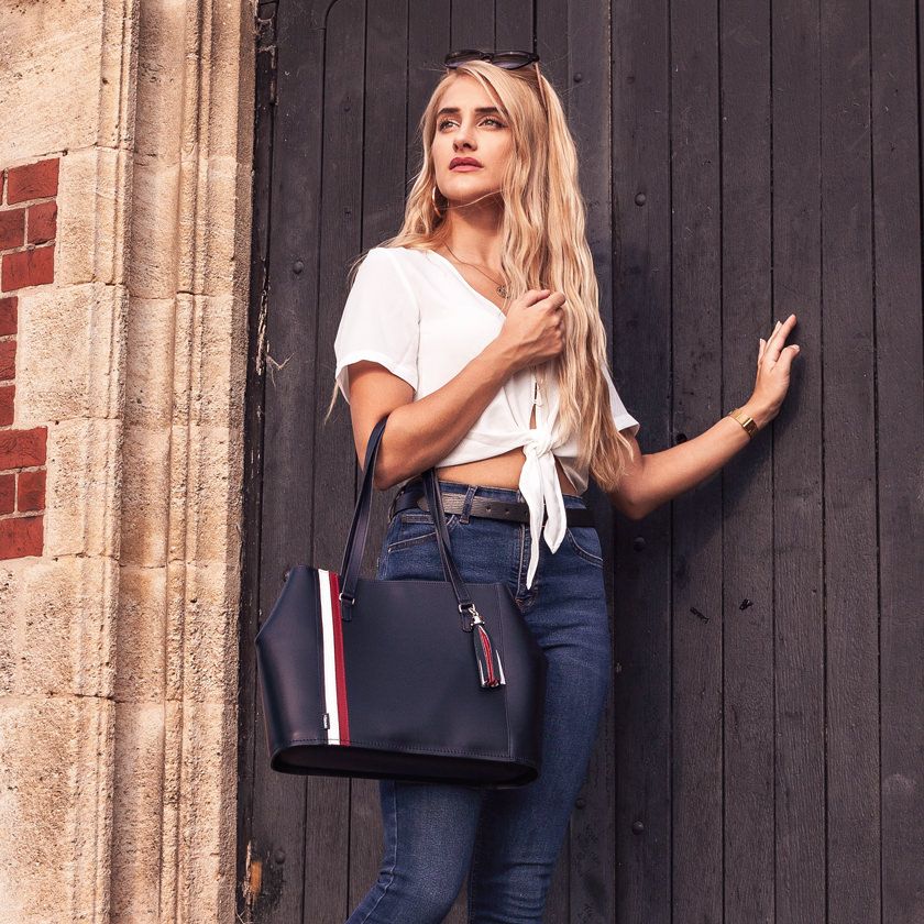 Woman By A Door Holding A Zatchels British Edit Handmade Leather Tote Bag
