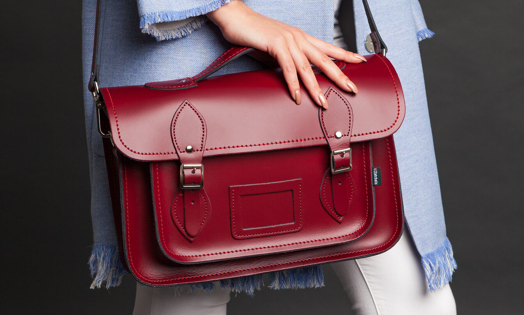 Oxblood Red Handmade Leather Satchel helf by woman wearing blue shirt