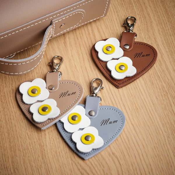 Love Heart Bag Charms with 'mum' engraving and flower appliques on a wooden surfacee