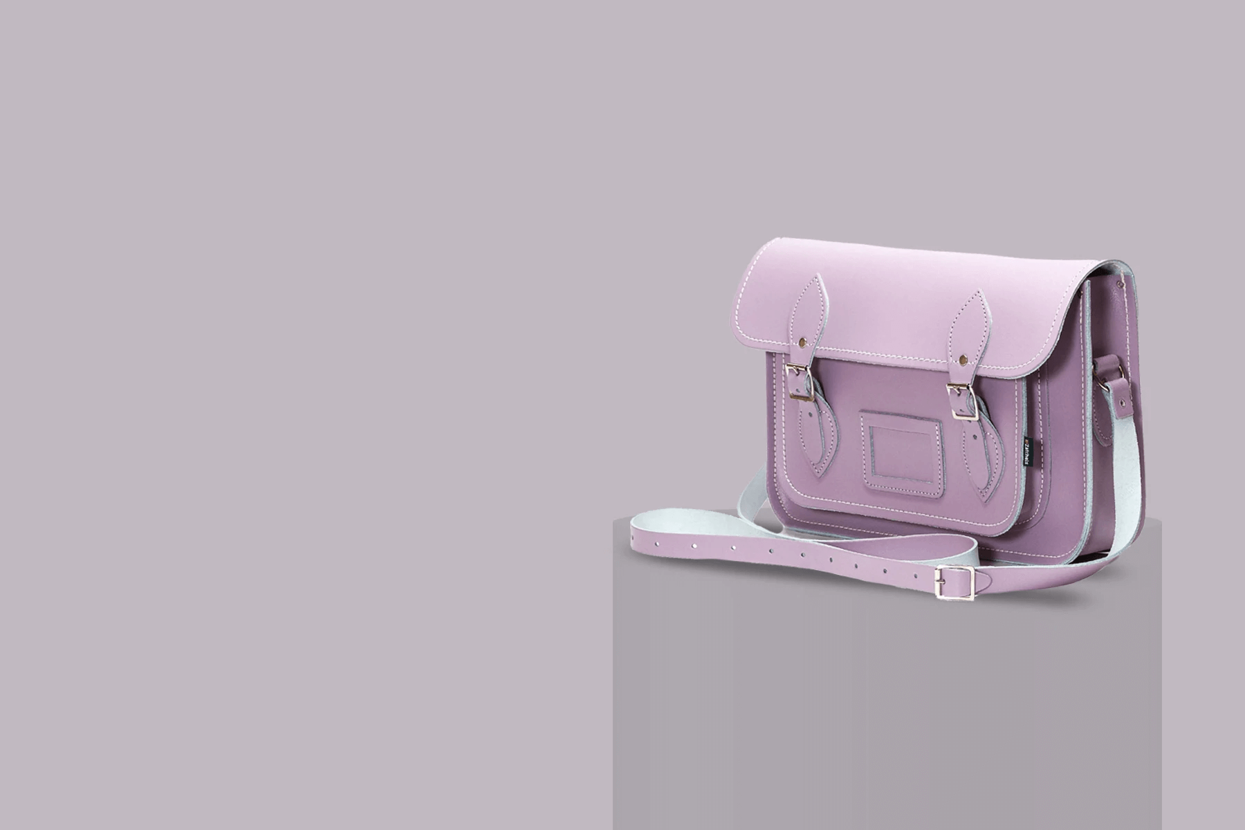 handmade leather satchel in pastel violet on a grey background