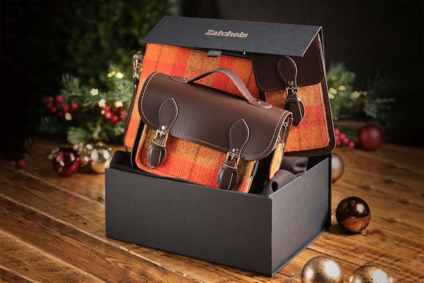Zatchels midi tweed collection gift set in orange check/brown leather placed next to Christmas baubles and decorations