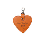 Heart-shaped leather keychain with 'Best Teacher Ever' text on a beige background