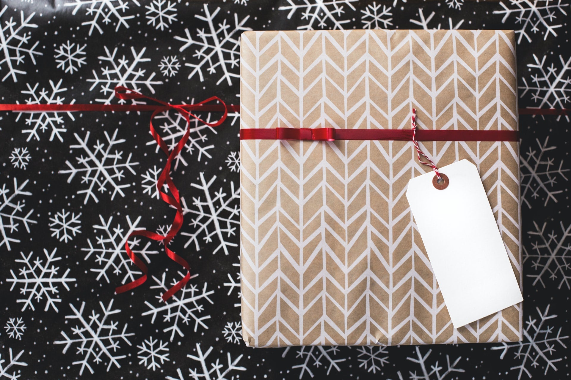A well wrapped Christmas gift on a black background covered in Snoflakes