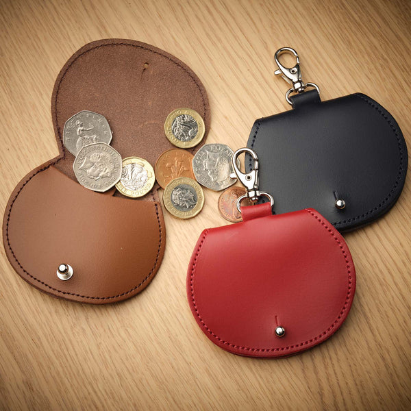 saddle bag coin purse bag charms in an assortment of colours on a wooden background