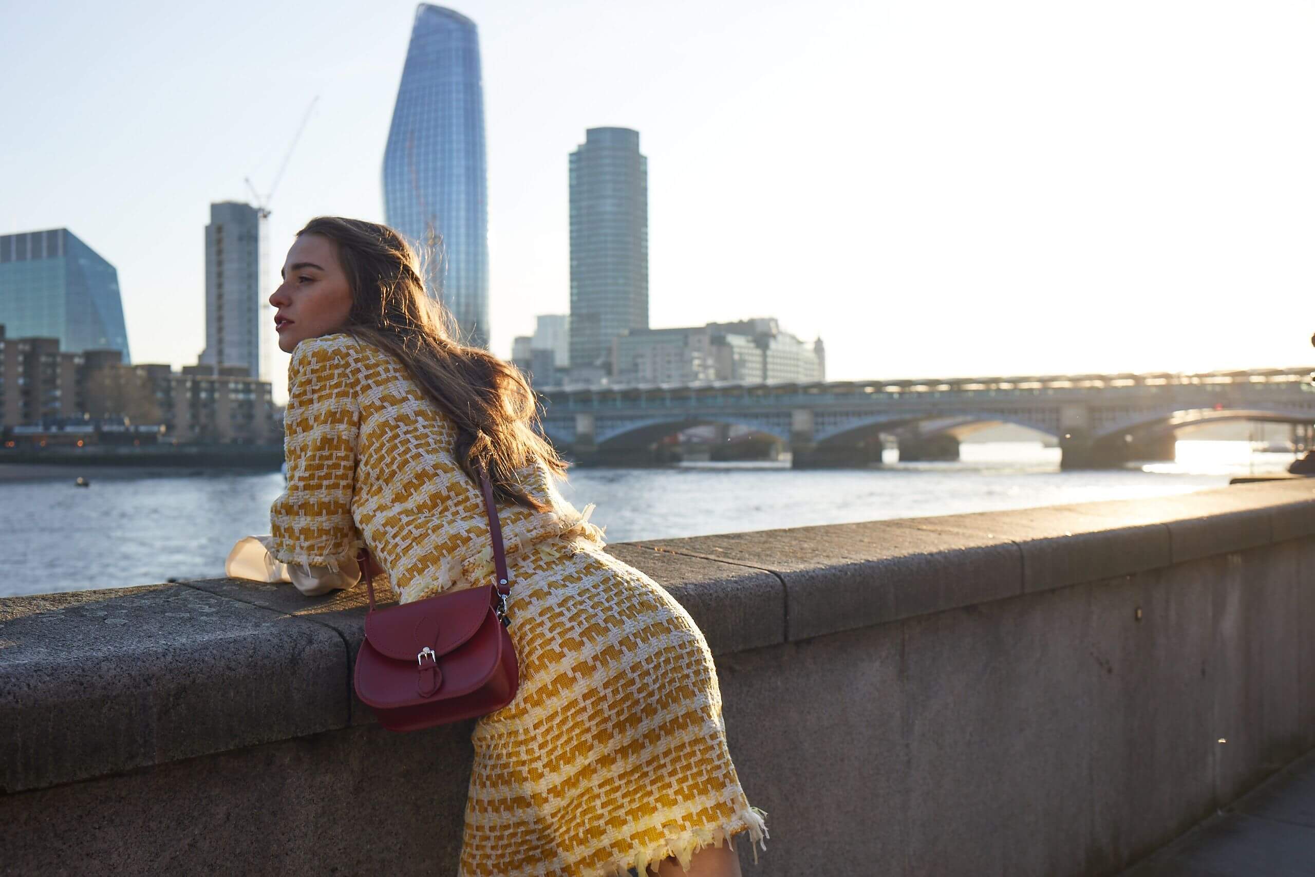 Woman with Zatchels Handmade Leather Handbag leaning on a wall