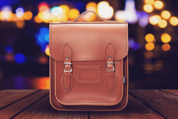 handmade leather city backpack in brown against a background of lights in focus 