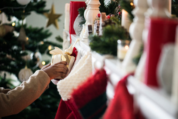 hand putting gifts in a christmas stocking