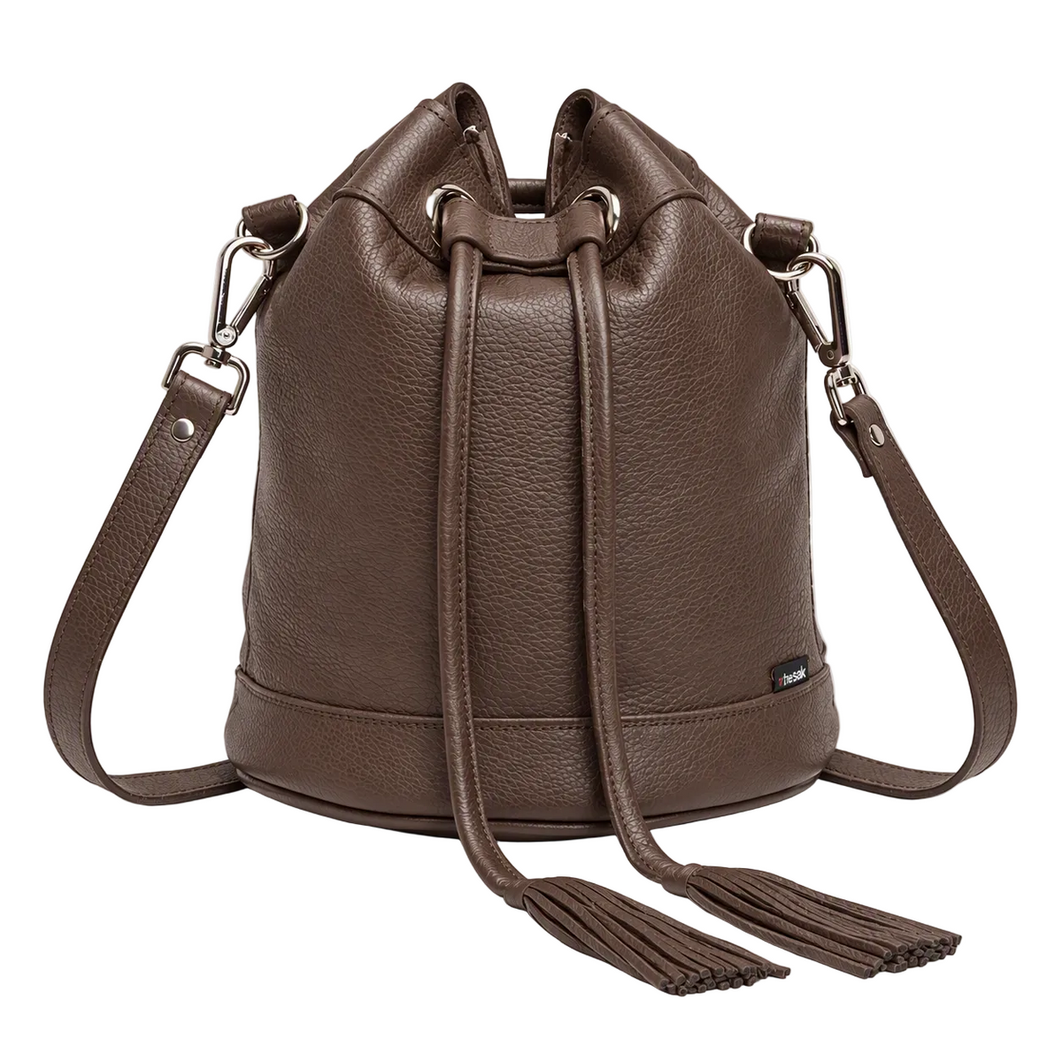 A brown pebbled leather bucket bag with a drawstring closure, dual shoulder straps, and tassel details, shown on a clean white background.