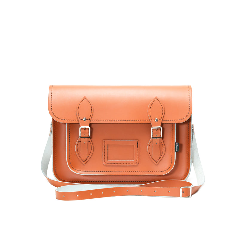 This image shows the front of a burnt orange coloured satchel on a plain white bacground