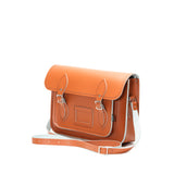 Thie image shows a burnt orange leather satchel at a slight angle on a plain white background