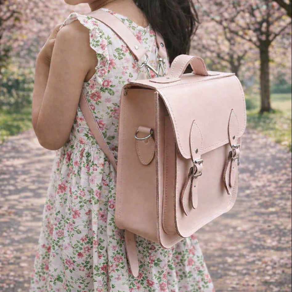 blossom on trees with young girl wearing a blossom pink leather backpack close up